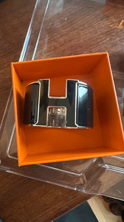 Hermès Clic Clac H bracelet featuring black enamel and palladium-plated hardware