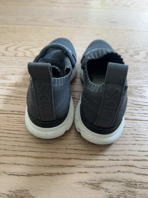 Tods Kate slip-on sneakers featuring a gray stretch-knit upper and a leather chain-style strap detail