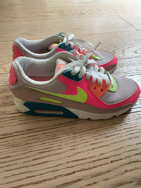 Nike Air Max 90 sneakers, specifically identified in a "Rose Ghost Green Volt" or neon "Exeter Edition" colorway